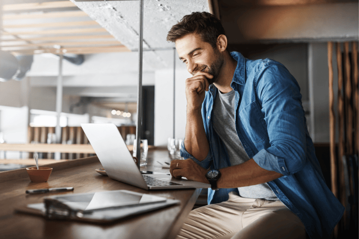 man smiling at laptop