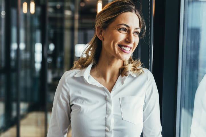 businesswoman smiling looking out of window