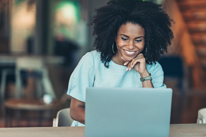 woman looking at laptop and smiling