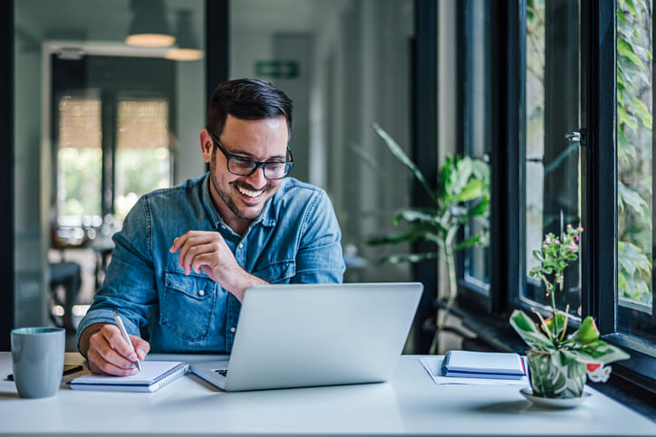 man looking at laptop and smiling